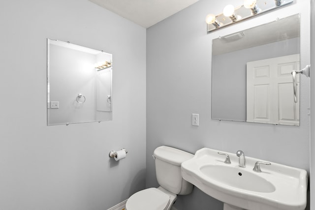 bathroom with visible vents, a sink, and toilet