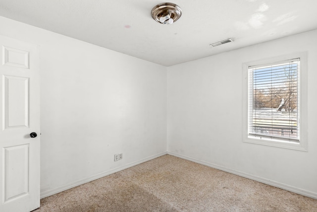 spare room with baseboards, visible vents, and carpet flooring