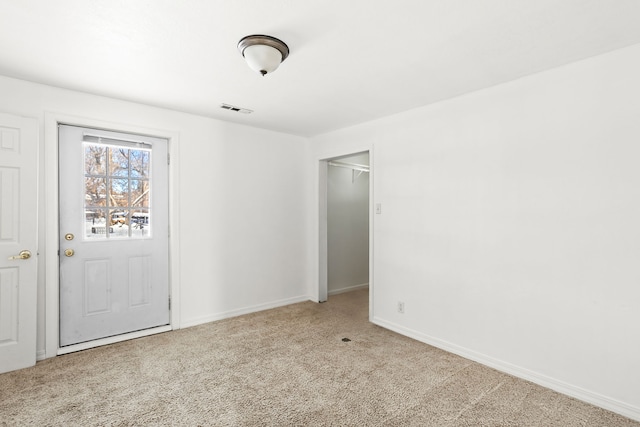 carpeted empty room with visible vents and baseboards