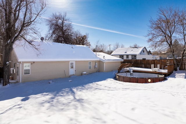 snow covered back of property with fence