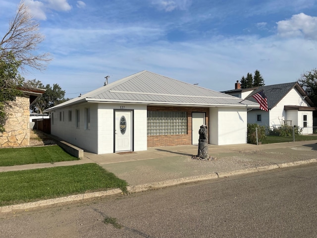 single story home with concrete block siding and metal roof