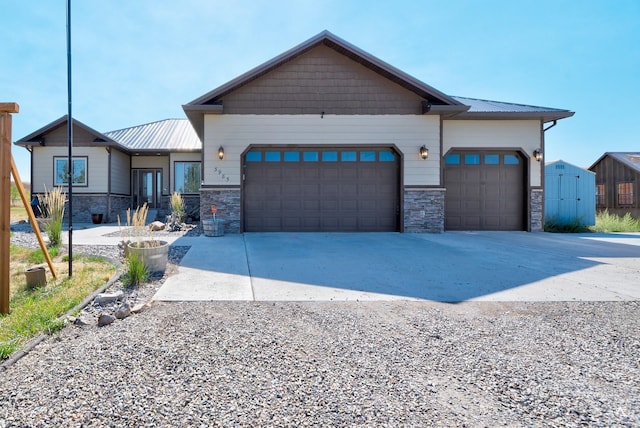 view of front of home featuring a garage, stone siding, and metal roof