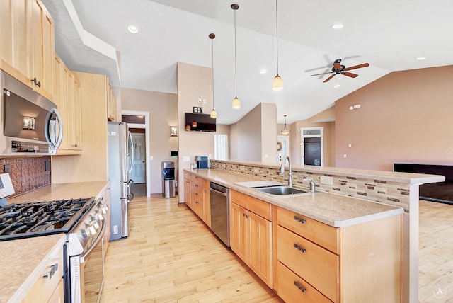 kitchen featuring decorative light fixtures, stainless steel appliances, light countertops, light brown cabinets, and a sink