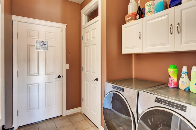 washroom with cabinet space, baseboards, washer and clothes dryer, and light tile patterned flooring