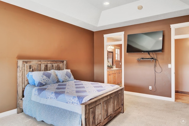 bedroom featuring light carpet, connected bathroom, and baseboards