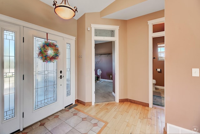 foyer entrance featuring light wood-type flooring, visible vents, and baseboards