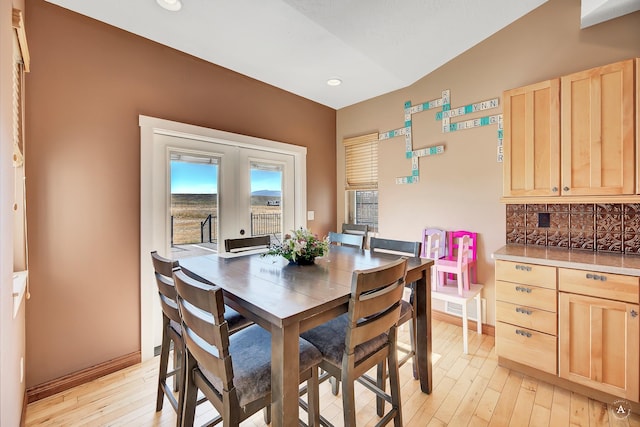 dining area featuring light wood-style floors, french doors, and baseboards