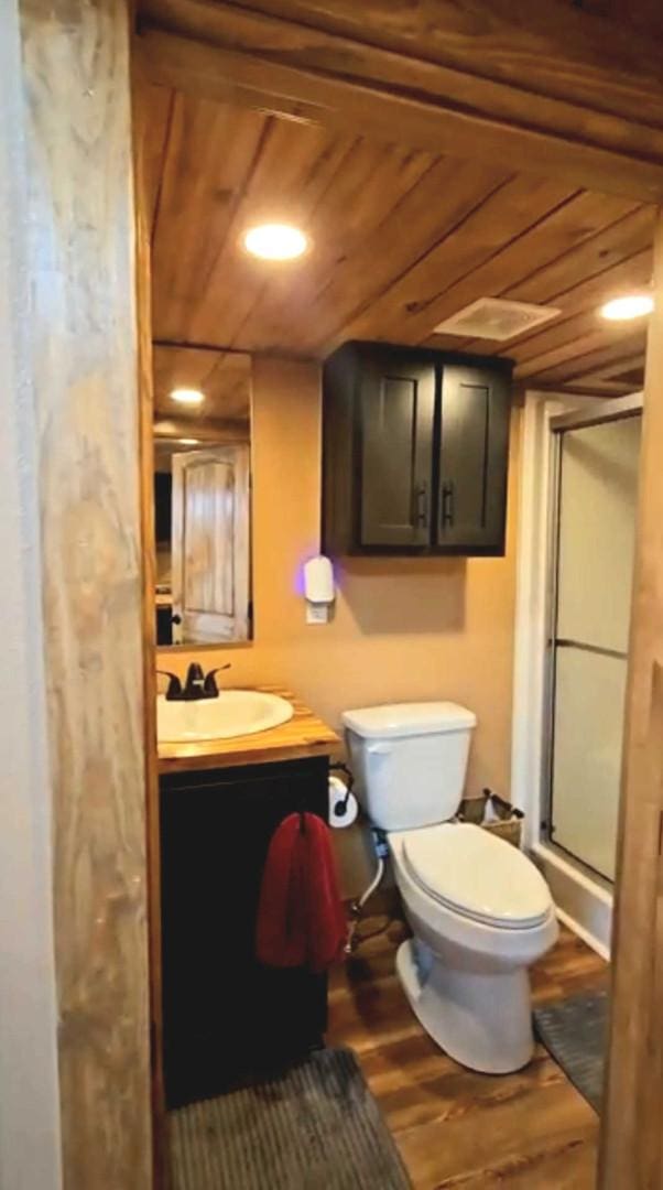301 Kingfisher Loop, Eureka, MT 59917 - full bathroom featuring a stall shower, wood finished floors, toilet, vanity, and wooden ceiling