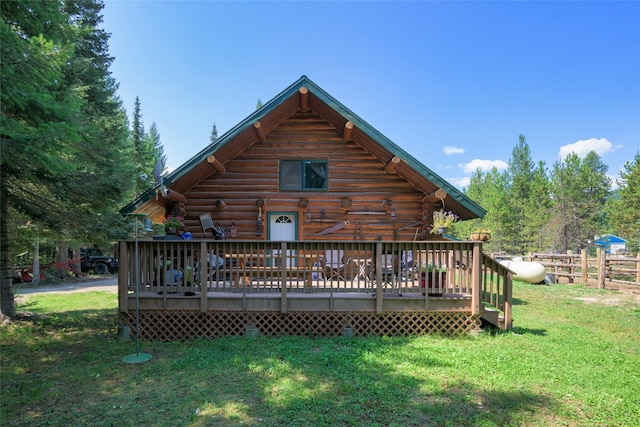 rear view of property featuring a deck, log exterior, and a yard