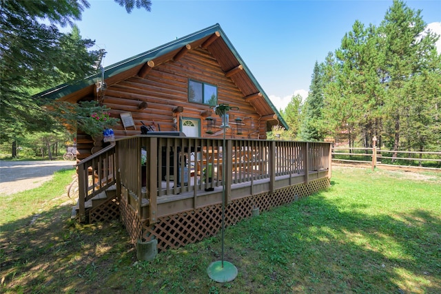 rear view of property with a yard, fence, a wooden deck, and log siding