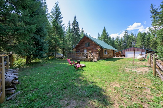 view of yard featuring a garage, driveway, an outdoor structure, and a deck