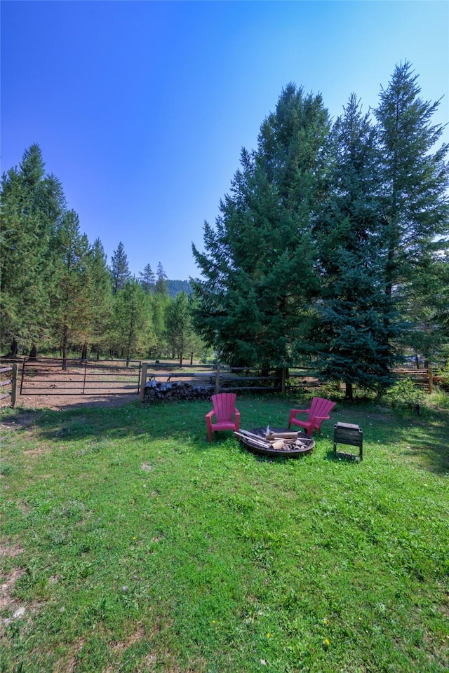 view of yard featuring an outdoor fire pit and fence