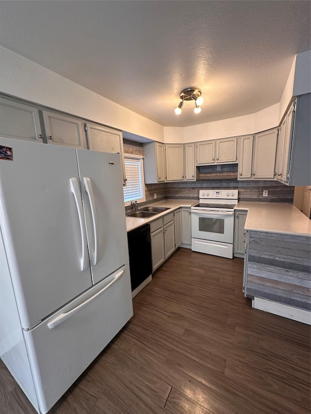 kitchen with white appliances, dark wood-style floors, gray cabinets, light countertops, and under cabinet range hood