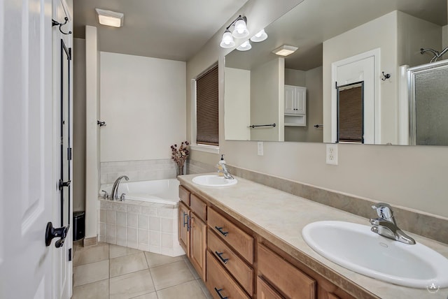 full bath featuring a garden tub, tile patterned flooring, a sink, and a shower stall