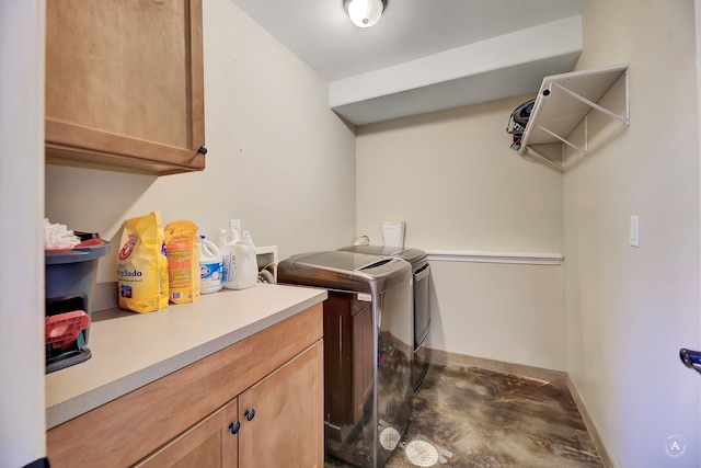 laundry room featuring cabinet space, baseboards, and washer and clothes dryer