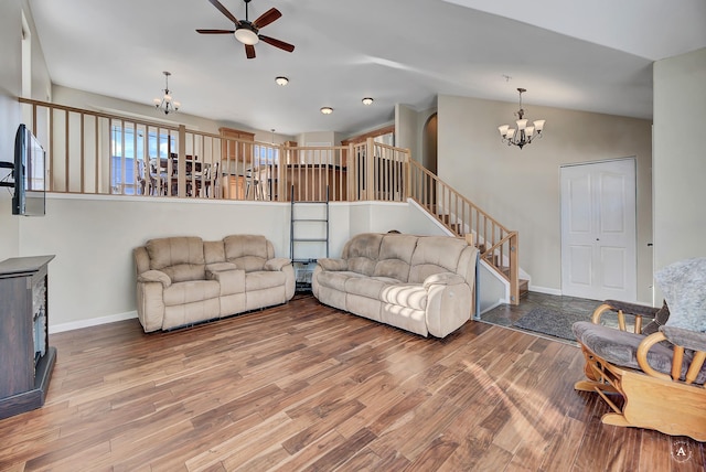 living room with vaulted ceiling, stairway, wood finished floors, and baseboards