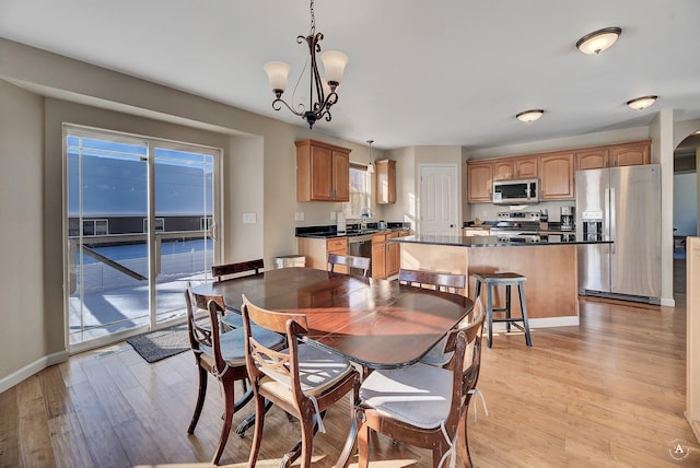 dining space with plenty of natural light, light wood-style flooring, and baseboards