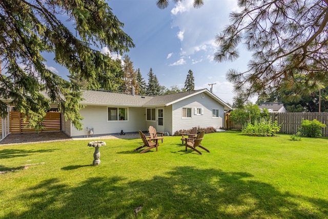 rear view of property with fence and a lawn