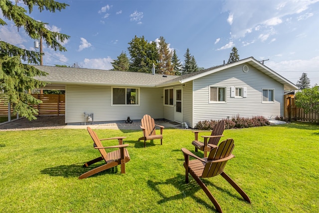 rear view of property with fence, a lawn, and a patio