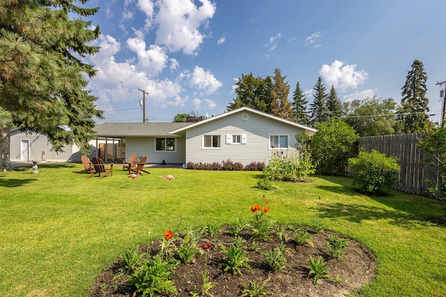 rear view of property with fence and a lawn