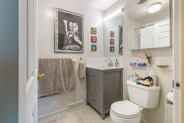 bathroom with toilet, vanity, visible vents, and baseboards