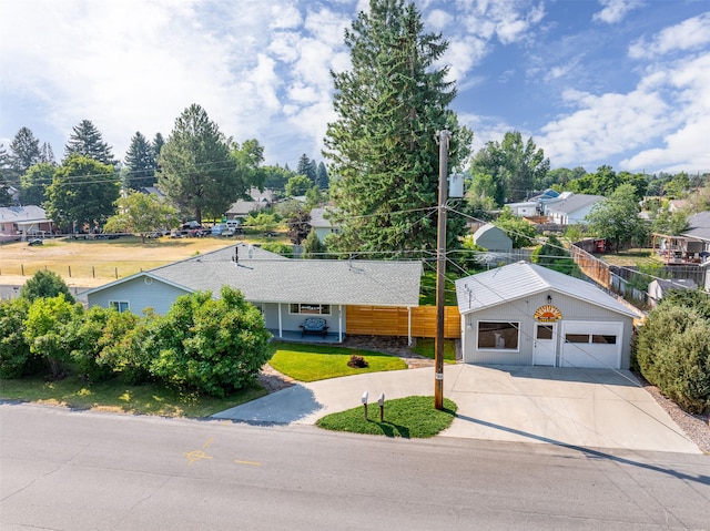 view of front facade with a residential view, fence, and driveway