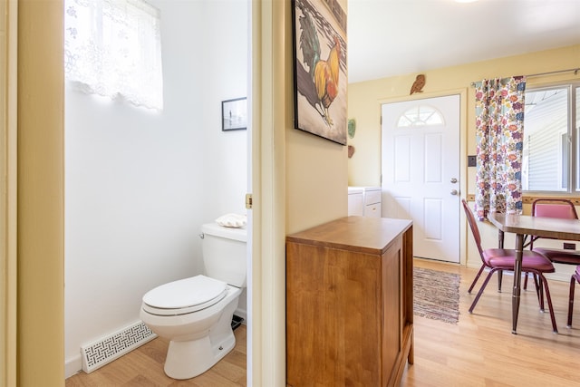 bathroom featuring baseboards, visible vents, toilet, and wood finished floors