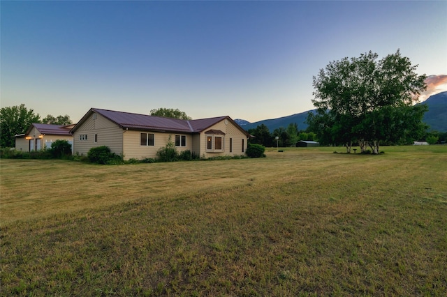 ranch-style home featuring a front yard, metal roof, and a mountain view