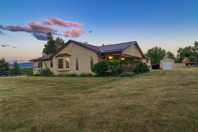 4901 Hoblitt Ln S, Florence, MT 59833 - property exterior at dusk featuring an outdoor structure, a yard, a detached garage, and metal roof