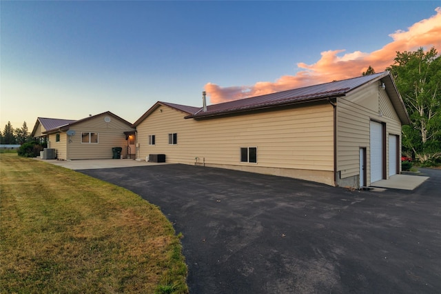 4901 Hoblitt Ln S, Florence, MT 59833 - view of home's exterior with metal roof, central AC, a yard, and a garage