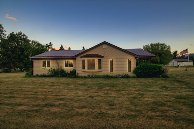 view of front of house with metal roof and a yard