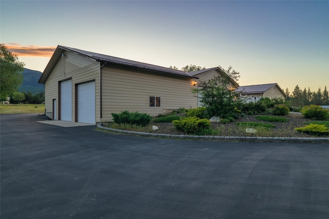 4901 Hoblitt Ln S, Florence, MT 59833 - property exterior at dusk featuring a detached garage and metal roof
