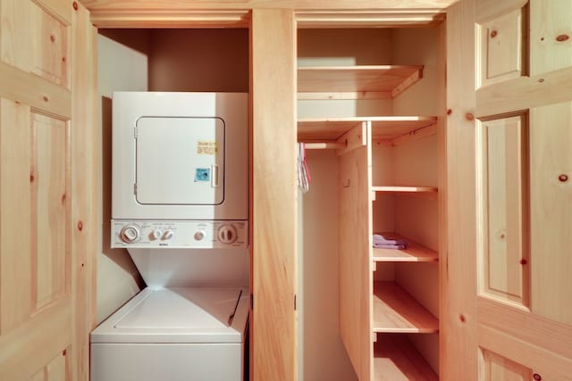 washroom featuring stacked washer and clothes dryer