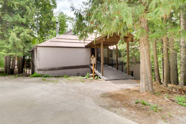 view of home's exterior with metal roof and crawl space