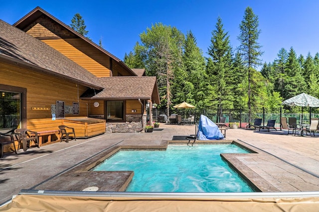 view of pool with a fenced in pool, fence, a patio, and a jacuzzi