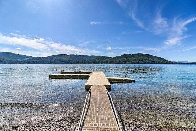 view of dock with a water and mountain view