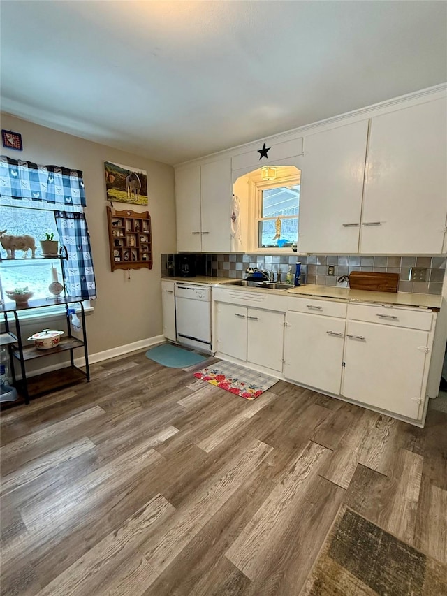 kitchen featuring wood finished floors, white cabinetry, light countertops, backsplash, and dishwasher