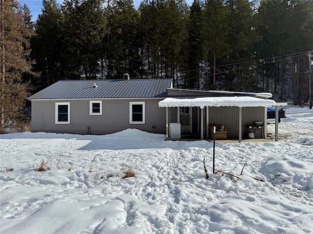 snow covered property with metal roof