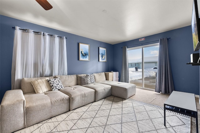 living area featuring light colored carpet and ceiling fan