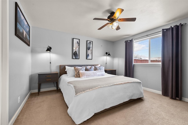 bedroom featuring light colored carpet, ceiling fan, and baseboards