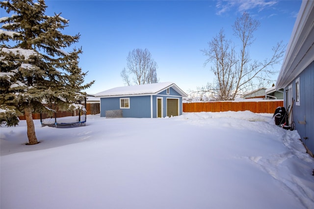 exterior space featuring a garage, an outbuilding, and a fenced backyard