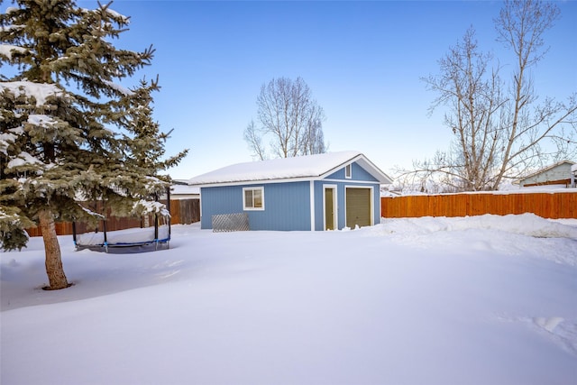 exterior space with a garage, an outdoor structure, and fence