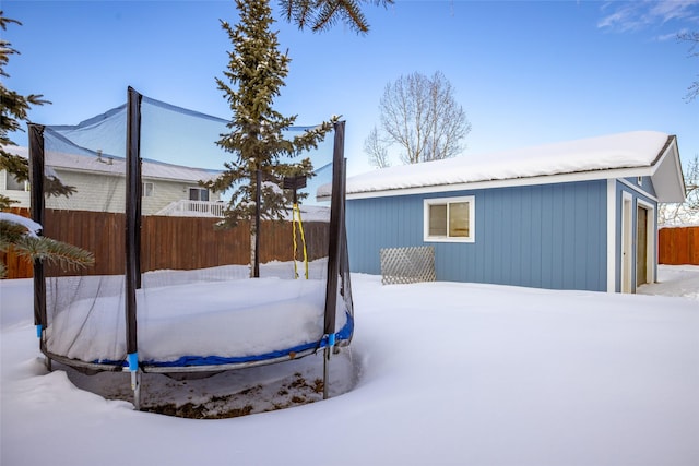 yard covered in snow with a garage and fence