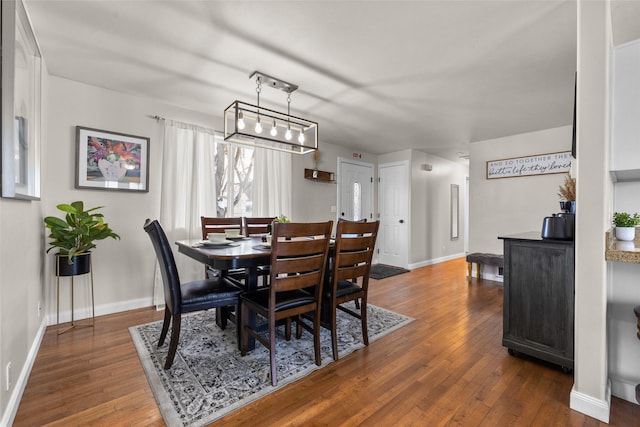 dining space with baseboards and dark wood-type flooring