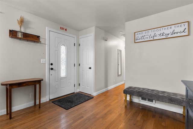 foyer featuring baseboards and wood finished floors