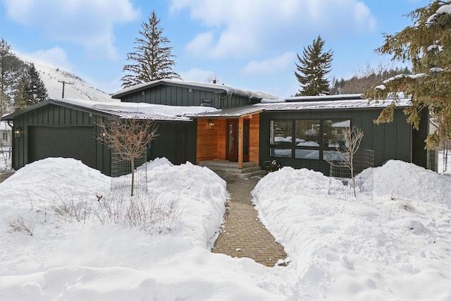 view of front of property with a standing seam roof, metal roof, board and batten siding, and a garage