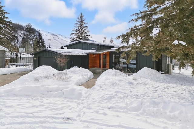 view of front of home with a garage, board and batten siding, and a mountain view