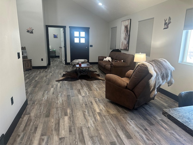 living room with dark wood-style floors, high vaulted ceiling, and baseboards