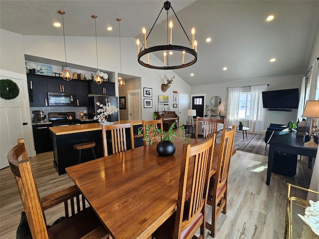 dining room with high vaulted ceiling, recessed lighting, and light wood finished floors