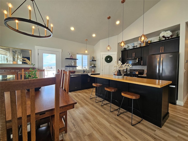 kitchen featuring black appliances, open shelves, dark cabinets, and a center island